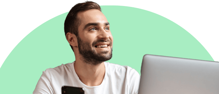 Man looking up to features in front of phone and laptop
